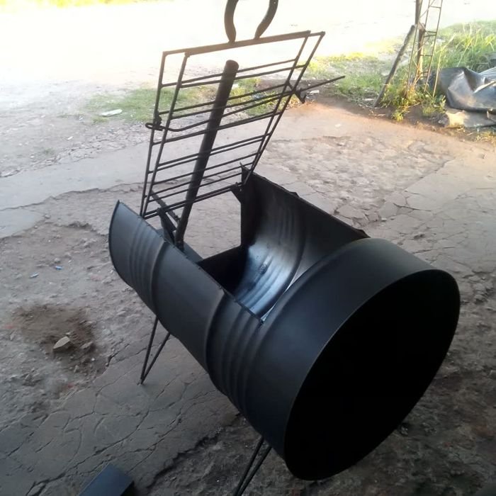 Estaca libro de hierro junto a un asador de medio tambor